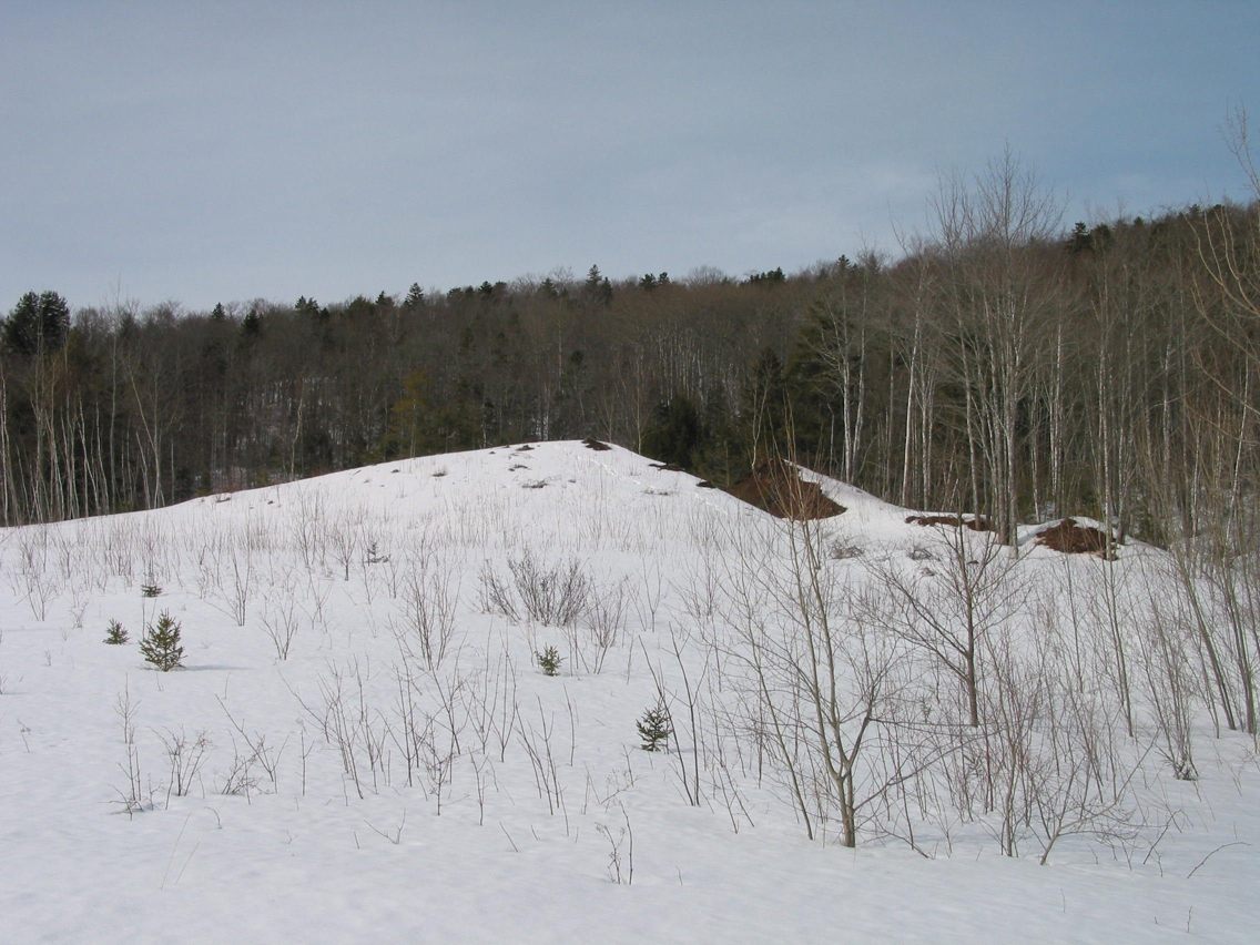 building site is large moraine to left of melted 'V' cut access to gully