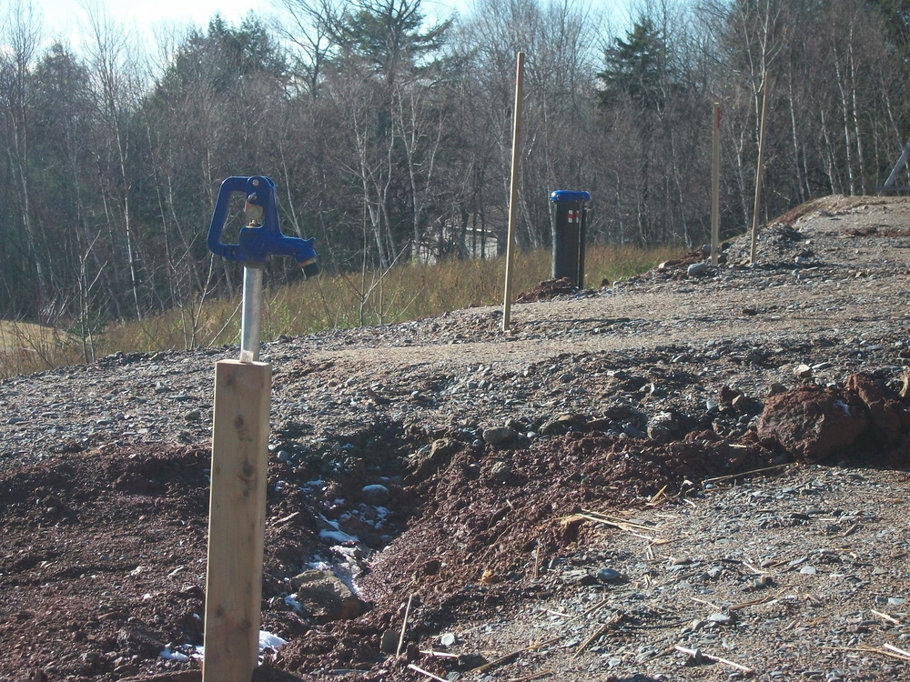 Garden hydrant and well casing in the distance.